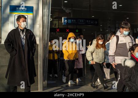 I pendolari del mattino escono dall'uscita della metropolitana a Zhongguancun, centro tecnologico di Pechino, Cina. 27-dic-2021 Foto Stock