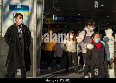 I pendolari del mattino escono dall'uscita della metropolitana a Zhongguancun, centro tecnologico di Pechino, Cina. 27-dic-2021 Foto Stock