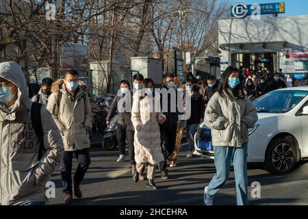 I pendolari del mattino escono dall'uscita della metropolitana a Zhongguancun, centro tecnologico di Pechino, Cina. 27-dic-2021 Foto Stock