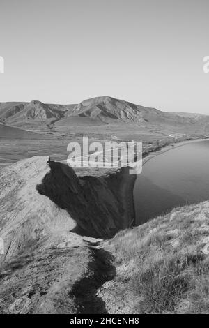 Ripide scogliere alte, vista dall'alto del mare e della spiaggia, foto in bianco e nero. Foto di alta qualità Foto Stock