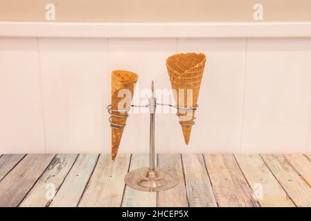 Un cono per gelato o un cono per gelato è una pasta secca a forma di cono, di solito fatta da un waffle, che consente di avere il gelato senza bisogno di un b Foto Stock