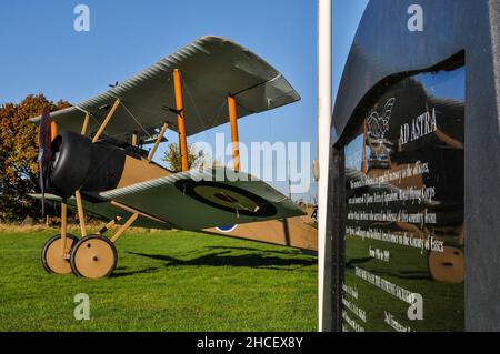 Memorial Stone presso lo storico stow Maries aerodrome di Essex, Regno Unito, con un aereo da caccia Sopwith del periodo Royal Flying Corps World War One. Foto Stock