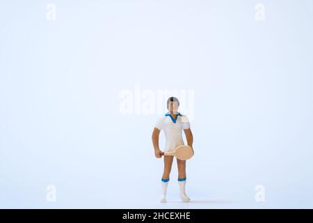 Atleta di tennis in miniatura con racchetta da tennis su sfondo bianco Foto Stock