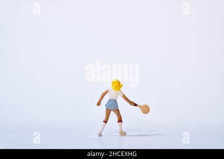 Atleta di tennis in miniatura con racchetta da tennis su sfondo bianco Foto Stock