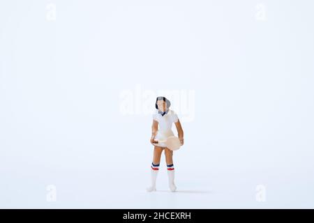 Atleta di tennis in miniatura con racchetta da tennis su sfondo bianco Foto Stock