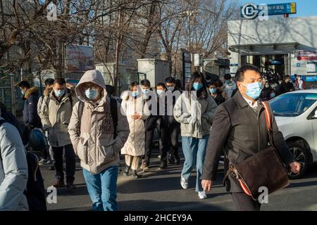 I pendolari del mattino escono dall'uscita della metropolitana a Zhongguancun, centro tecnologico di Pechino, Cina. 27-dic-2021 Foto Stock