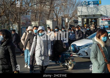 I pendolari del mattino escono dall'uscita della metropolitana a Zhongguancun, centro tecnologico di Pechino, Cina. 27-dic-2021 Foto Stock