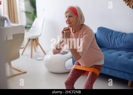 Signora anziana che fa l'allenamento di idoneità a casa Foto Stock