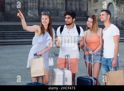 Gruppo di giovani che viaggiano utilizzando una mappa cartacea in città Foto Stock