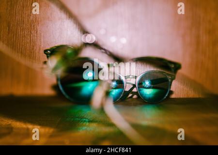 Primo piano di un paio di occhiali da sole su una superficie di legno Foto Stock