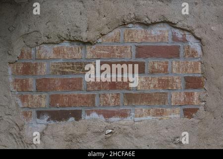 Il vecchio muro di mattoni in una immagine di sfondo. Brickwall intonacata con stucco scheggiati pezzi. Rosso mattone testurizzata parete con superficie di danno. Il vecchio Grunge Abstract Foto Stock