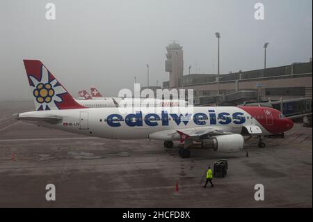 14.12.2021, Zurigo, Svizzera, Europa - un aereo Edelweiss Air Airbus A320 passeggeri è parcheggiato in un cancello del Terminal A dell'aeroporto di Zurigo. Foto Stock