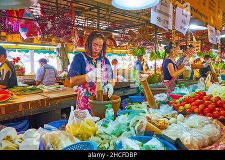 CHIANG mai, THAILANDIA - 4 MAGGIO 2019: Il mercato del Tanin è famoso per i gustosi cibi locali, il venditore di una piccola stalla prepara insalata speziata di verdure w Foto Stock