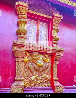 La finestra decorativa in legno intagliato del Viharn del Tempio d'Argento con scultura da parete del Re demone di Yaksha, colonne, motivi floreali, Chiang mai, Thailandia Foto Stock