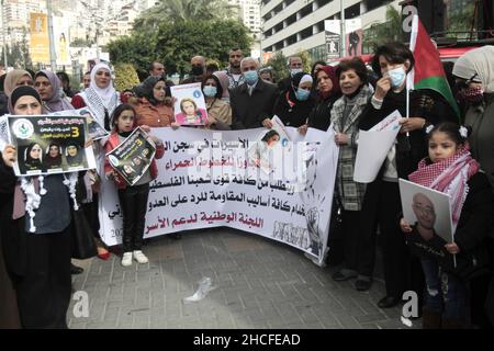 Nablus, Palestina. 28th Dic 2021. I palestinesi hanno visto tenere una bandiera e dei cartelli che mostrano i ritratti dei prigionieri durante la manifestazione a sostegno dei prigionieri in sciopero della fame. I manifestanti chiedono il rilascio dei prigionieri palestinesi nella prigione israeliana. (Foto di Nasser Ishtayeh/SOPA Images/Sipa USA) Credit: Sipa USA/Alamy Live News Foto Stock