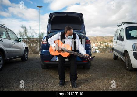 Malaga, Spagna. 28th Dic 2021. Un partecipante ad un costume tradizionale che sintonizza la sua chitarra prima del festival. L'edizione 59th del concorso di danza Verdiales Flamenco, un importante festival culturale e musicale di origine rurale, si celebra ogni anno nella Fools Saints Day. I musicisti di diversi gruppi musicali noti come 'pandas' competono in uno stile di musica di flamenco e di ballo di concorso chiamato 'Verdiales' utilizzando strumenti musicali tipici del folklore popolare andaluso. Credit: SOPA Images Limited/Alamy Live News Foto Stock