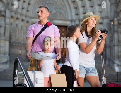 Famiglia turistica che usa la mappa e scatta foto della città mentre passeggi Foto Stock