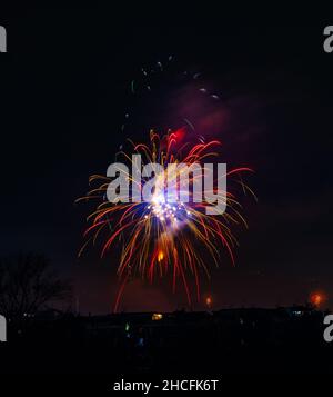 Colpo verticale di splendidi fuochi d'artificio esplosi nel cielo notturno di Napoli Foto Stock