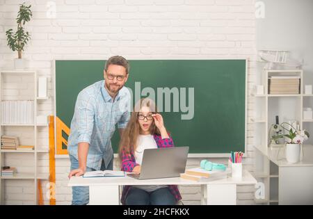 aiuto di famiglia. papà e figlia vicino al clackboard. ritorno a scuola. educazione infantile. Foto Stock