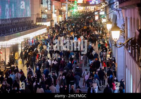 Madrid, Spagna. 28th Dic 2021. Grande folla di persone che indossano maschere per il viso per fermare la diffusione del coronavirus (COVID-19) è visto in via Preciados, nel centro di Madrid, nonostante il grande aumento dei casi positivi. Il Ministero della Salute ha notificato 99.671 nuovi positivi al conteggio ufficiale COVID questo martedì e l'incidenza cumulativa sale a 1.360 casi per 100.000 abitanti negli ultimi 14 giorni. Credit: Marcos del Maio/Alamy Live News Foto Stock