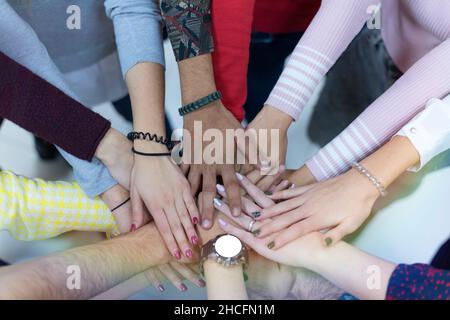 Gli studenti universitari del lavoro di squadra di impilamento concetto a mano Foto Stock