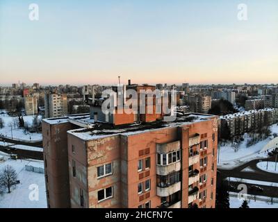 Vista aerea delle antenne GSM e delle telecomunicazioni sul tetto dell'edificio urbano a più piani Foto Stock