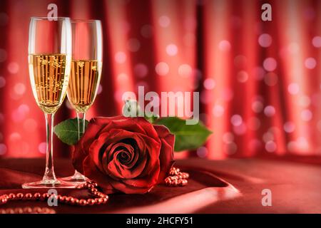 san valentino, bicchieri da champagne da matrimonio e un fiore di rosa rosso sul tavolo. Cena romantica o incontri di Natale. Foto Stock