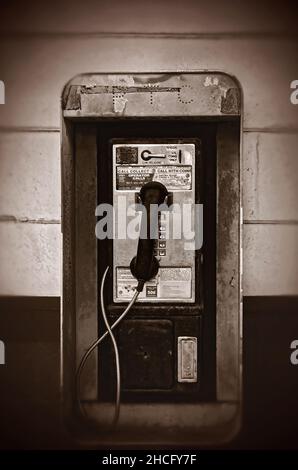 Un telefono pubblico a gettoni chiamato anche un telefono a pagamento, appende sul muro al di fuori di Coden Grocery, 27 dicembre 2021, a Coden, Alabama. Foto Stock