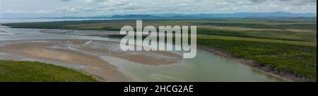 Panorama di un fiume marea con sbarre di sabbia e le rive fiancheggiate da mangrovie e altri alberi tolleranti acqua salata Foto Stock