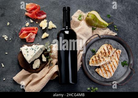 Sirah vino rosso con antipasti su sfondo grigio. Bevande alcoliche tradizionali. Vista dall'alto, piatto Foto Stock