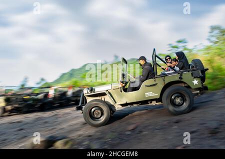 Famiglia a cavallo di una vecchia jeep willys . Foto Stock