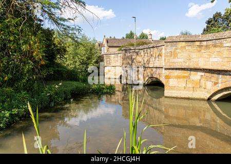 Il Fiume Windrush che scorre sotto il vecchio ponte in pietra del Cotswold città di Burford, Oxfordshire, Regno Unito Foto Stock