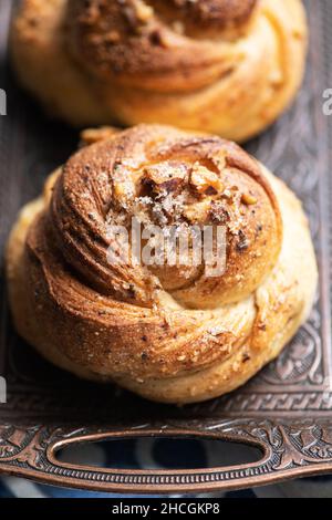 Noci appena sfornate e panini dolci al cardamomo. Pasticceria lievitata e cottura accogliente. Primo piano. Foto Stock