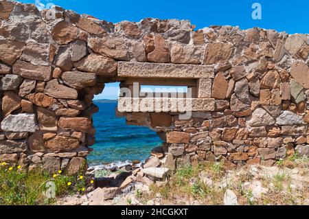 Antico muro di pietra dilapidata con un foro rettangolare con vista sul mare a Pesaro, Italia Foto Stock