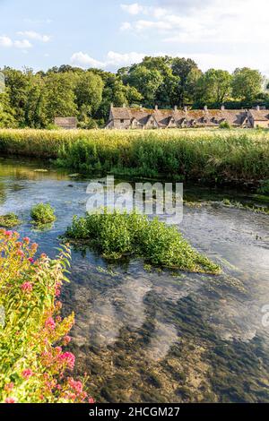 Sera luce cadere su Arlington Row, fine 14th secolo tessitori cottage accanto al fiume Coln nel villaggio di Cottswold di Bibury, Gloucestershire Regno Unito Foto Stock