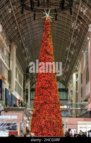 Il grande albero di Natale di colore rosso si trova all'interno del centro commerciale Eaton Centre. 29 dicembre 2021 Foto Stock