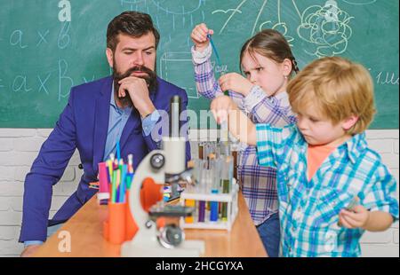 strumento ottico per microscopio in aula di scienza. ritorno a scuola. insegnante per bambini felici. imparare a usare il microscopio a lezione di scuola. Sviluppo precoce Foto Stock