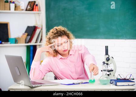 Pressione nervosa tesa. Educatore stressante. Professione stressante dell'insegnante. Ragazza stanca espressione stressante con laptop e microscopio funzionante Foto Stock