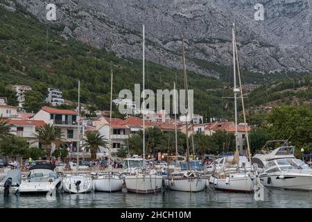 Ormeggiate barche a vela nel mare Adriatico in marina nella località turistica Baska Voda, Croazia contro la montagna Biokovo Foto Stock