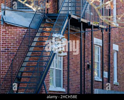 NEW ORLEANS, LA, Stati Uniti d'America - 23 DICEMBRE 2021: Sneakers appesi al filo con l'edificio di appartamento in background Foto Stock
