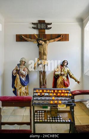 Cristo sulla croce, figure in lutto e candele sacrificali, Chiesa parrocchiale di San Magnus, Lenzfried, Kempten, alta Baviera, Baviera, Germania Foto Stock