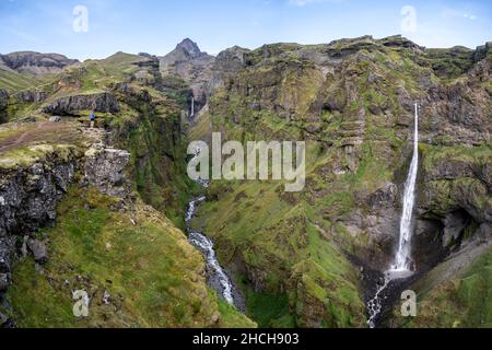 Paesaggio di montagna con canyon, cascata di Hangandifoss nel canyon di Mulagljufur, Sudurland, Islanda Foto Stock