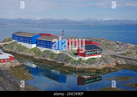 Moderni blocchi di appartamenti riflessi nel mare, Maniitsoq, Artico, Nord America, Groenlandia, Danimarca Foto Stock