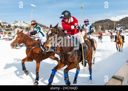 I giocatori del Team St. Moritz (rosso) e i giocatori del Team Azerbaijan Terra del fuoco (bianco) combattono per la palla sulla ferrovia, 36th Snow Polo World Cup St Foto Stock