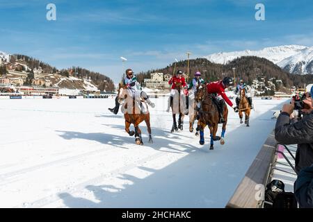 I giocatori del Team St. Moritz (rosso) e i giocatori del Team Azerbaijan Terra del fuoco (bianco) combattono per la palla sulla ferrovia, 36th Snow Polo World Cup St Foto Stock