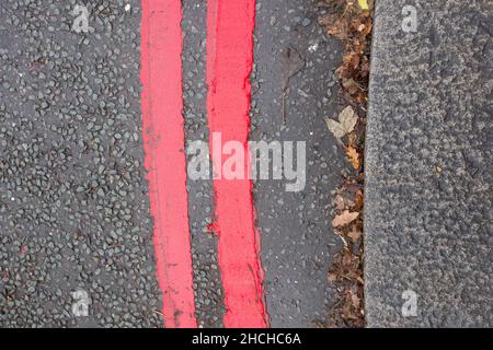 Primo piano di due linee rosse che indicano un percorso rosso e che le regole e le normative si applicano sempre e tutti i giorni Foto Stock