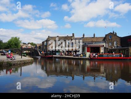 I turisti godono del sole nel bacino del canale sul canale di Leeds e Liverpool a Skipton, North Yorkshire, Inghilterra. Foto Stock