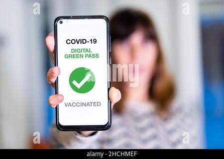 Passo verde del convivid-19, una donna mostra un telefono cellulare con il passaporto sanitario. Certificato di vaccinazione per l'ingresso in bar e ristoranti, coronavirus Foto Stock