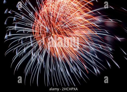 Flash di fuochi d'artificio rossi e bianchi sullo sfondo cielo nero. Concetto di vacanza. Primo piano Foto Stock