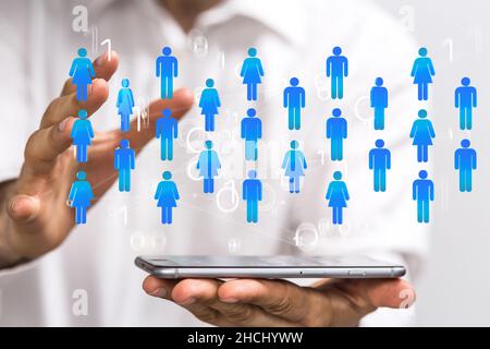 E le comunicazioni di sfondo tematico con icone digitali fluttuanti davanti alle mani Foto Stock